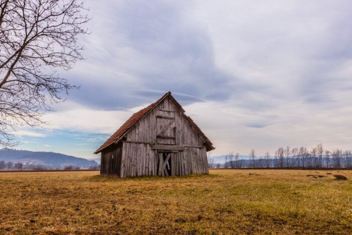 An image of a barn on a hilltop